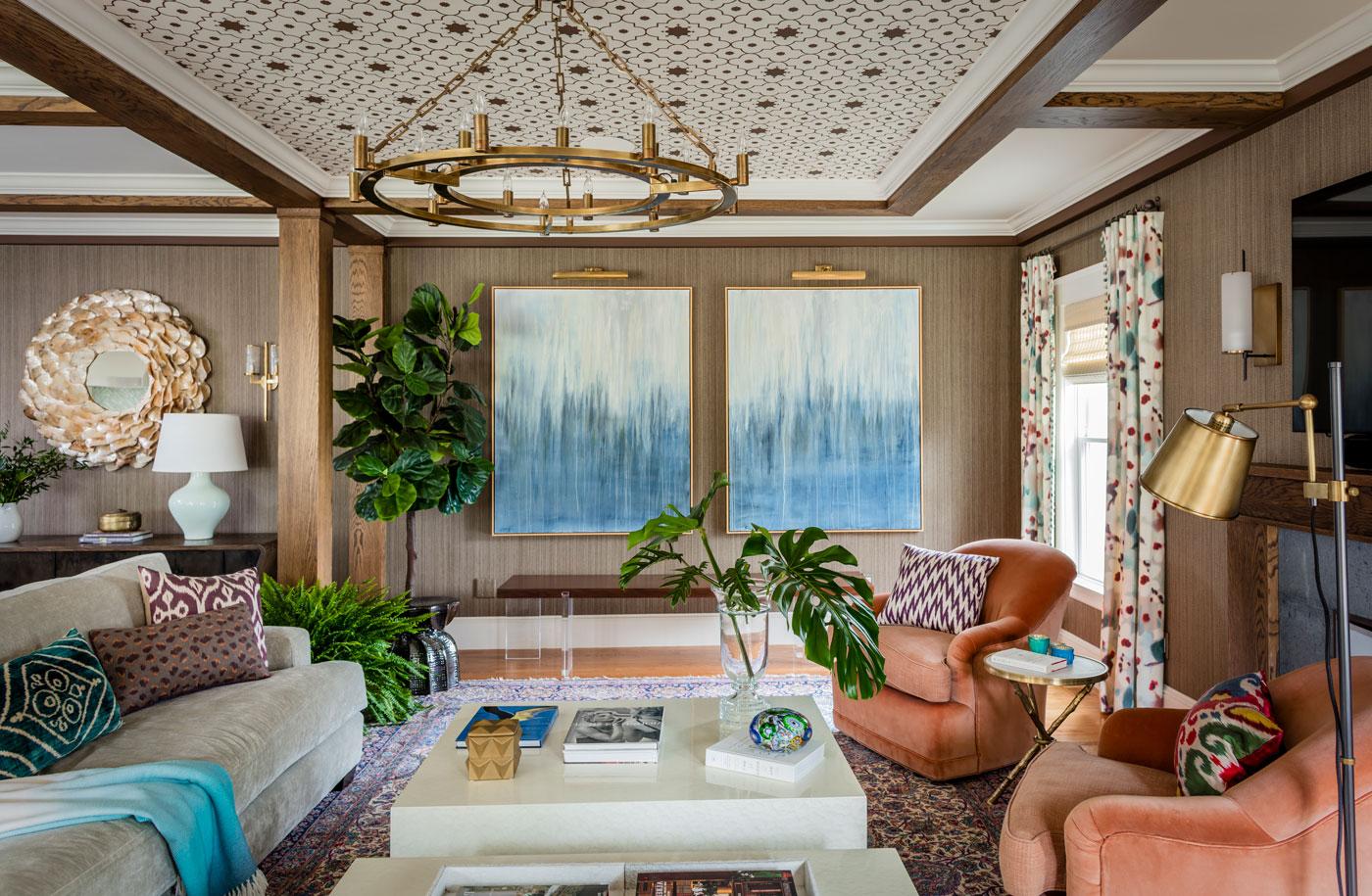 重新设计的家庭房，墙上有定制天花板上的蓝色抽象画和珊瑚色的椅子