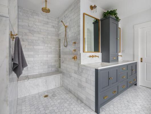 Remodeled master bath with White marble and unlacquered brass fixtures 